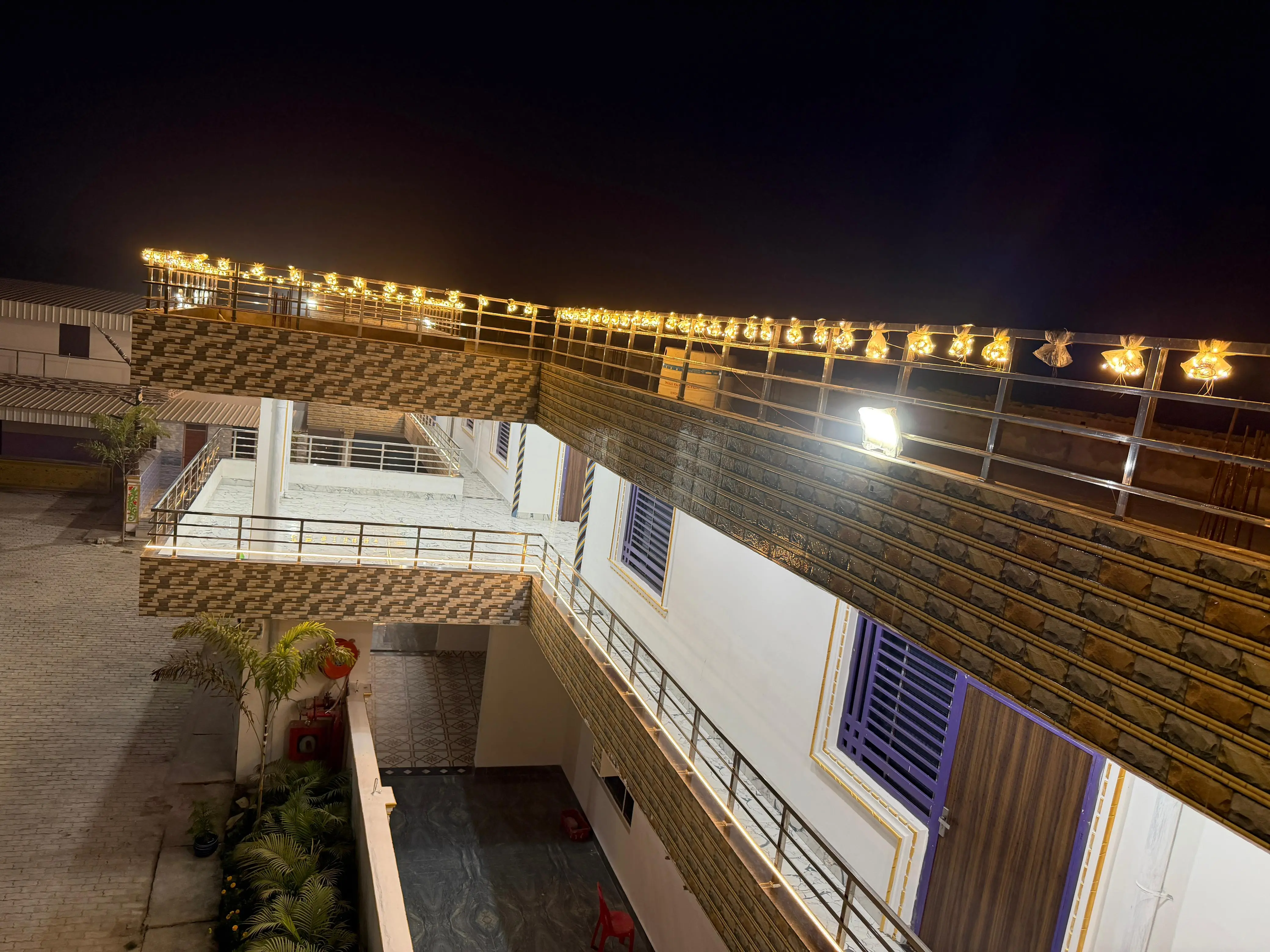 The upper terrace and balconies outlined in warm string lights at night